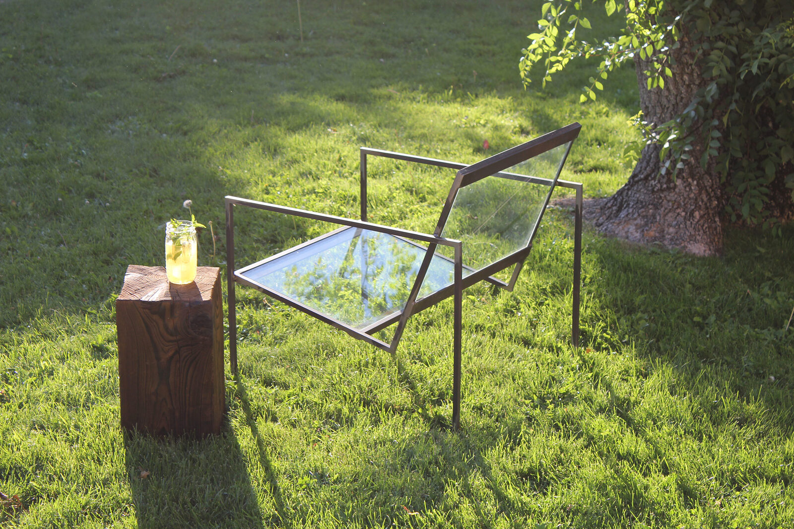 Asiento de estructura oscura y volúmenes de madera en un jardín